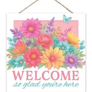 May include: Square wooden sign with a floral arrangement and the words "WELCOME so glad you're here." The flowers are in shades of pink, orange, yellow, and blue, with a light blue butterfly. A brown rope is attached for hanging.