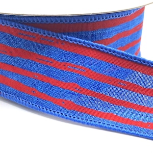 May include: A spool of decorative ribbon with alternating red and blue horizontal stripes. The ribbon has a textured appearance and a stitched edge. Ideal for crafting and gift wrapping.
