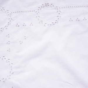 May include: White fabric with a delicate, embroidered pattern of circles and leaves. The fabric has a soft, textured surface.