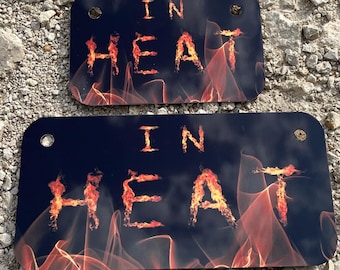 May include: Two black metal signs with the words "In Heat" written in orange flames on a black background.
