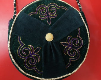 Round bag in dark green suede and ethnic style velvet with a long handle.