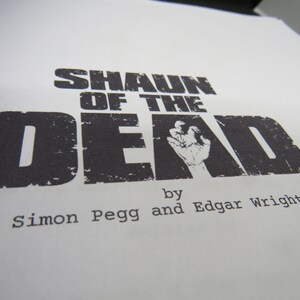 May include: Black and white title card for the film "Shaun of the Dead" by Simon Pegg and Edgar Wright.
