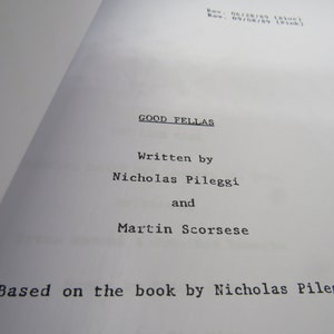 May include: A black and white title page for the screenplay of the movie "Goodfellas". The title page states that the screenplay was written by Nicholas Pileggi and Martin Scorsese and is based on the book by Nicholas Pileggi.