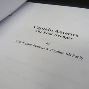 May include: A white page with the title "Captain America The First Avenger" by Christopher Markus & Stephen McFeely.