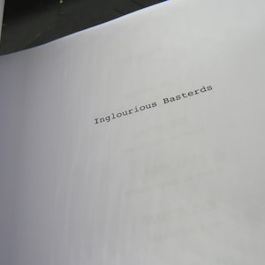 May include: A white page with the title "Inglourious Basterds" printed in black typewriter font.