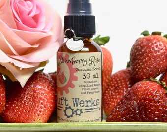 May include: A 30 ml bottle of Strawberry Rose Do-it-Yourself Perfume Scent. The bottle is brown glass with a black spray top and a white label with black text. The label says "Strawberry Rose Do-it-Yourself Perfume Scent 30 ml Contains Distilled Water, Witch Hazel, and Fragrance It Works"