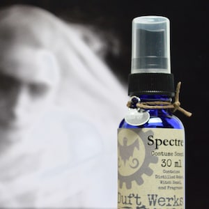 Pode incluir: Uma garrafa de vidro azul com um rótulo castanho que diz "Spectre Costume Scent 30 ml Contains Distilled Water, Witch Hazel, and Fragrance Duft Werks"