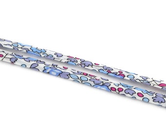 May include: Two strands of white fabric ribbon with a blue and pink floral pattern.