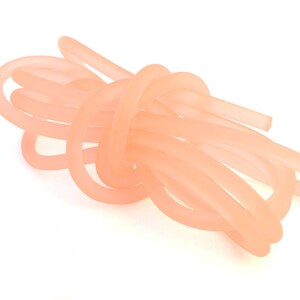 May include: A bundle of pale pink silicone tubing, twisted and knotted together.