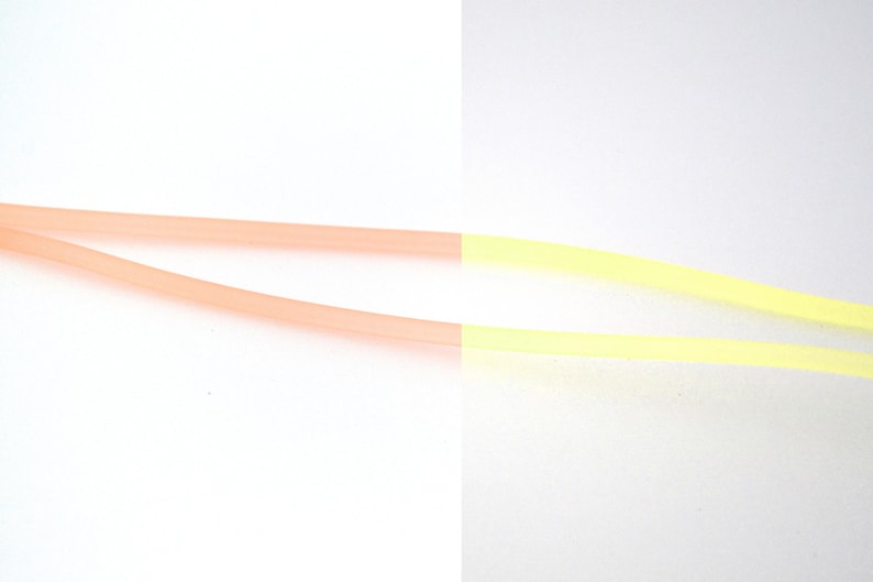 May include: Two flexible tubes, one pink and one yellow, are connected together. The tubes are made of a soft, pliable material.