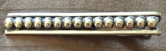 Vintage gold tone and mother of pearl tie pin in a sword design. yenihayathastan