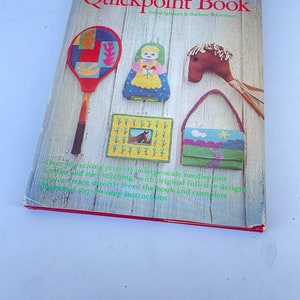 May include: The Quickpoint Book by Susan Iglehart and Barbara Schweizer. The book cover features needlepoint examples: a tennis racket, a doll, a horse head, a purse, and a framed horse image. The cover has a wooden plank background.