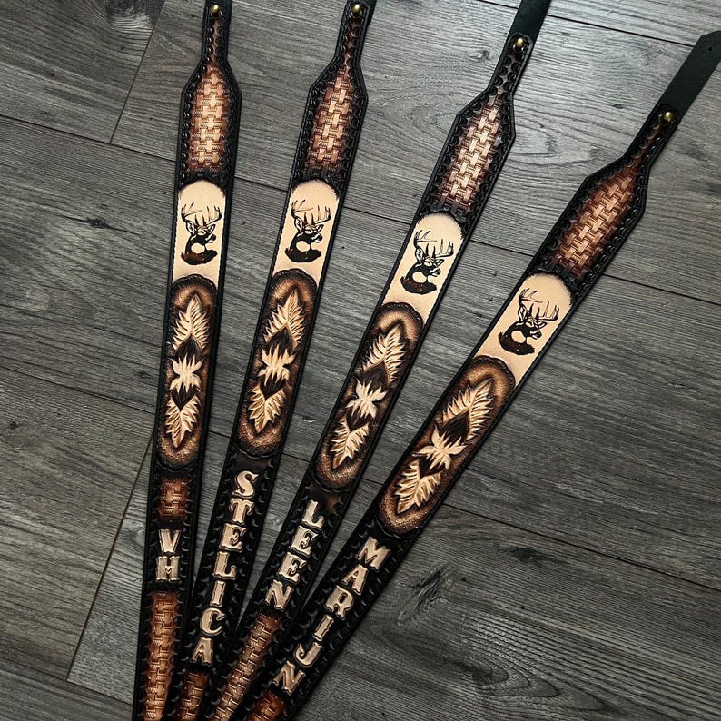 May include: Four brown leather guitar straps with a deer head design and personalized names: "VH", "STELICA", "LEEN", and "MARIJN".