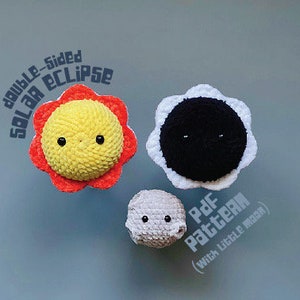 Puede incluir: Juguetes de peluche tejidos a crochet de un sol amarillo, una luna negra y una luna gris. El sol tiene un borde rojo y naranja. El texto "double-sided solar eclipse" está por encima del sol y el texto "Pdf Pattern (with little moon)" está por debajo de la luna.