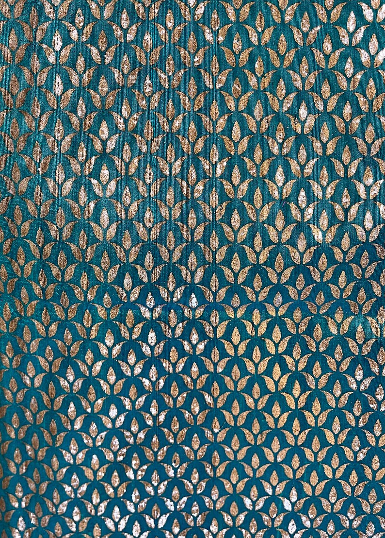 May include: Teal fabric with a repeating pattern of gold leaf stylized leaves.