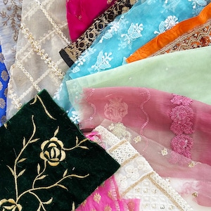 May include: Assortment of fabric swatches in various colors and textures, including lace, velvet, and sheer fabrics. The fabrics feature floral and geometric patterns.