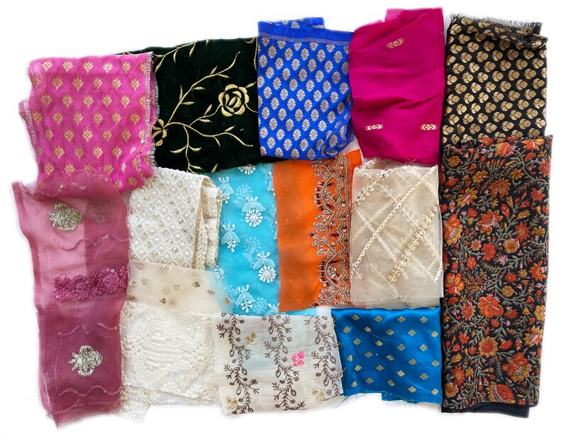 May include: Assortment of fabric scraps in various colors and patterns, including floral, geometric, and paisley designs. The fabrics are a mix of textures, including silk, cotton, and lace.