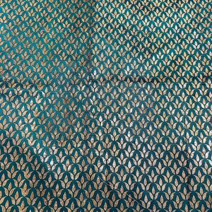 May include: Teal fabric with a repeating pattern of gold leaf stylized floral motifs.
