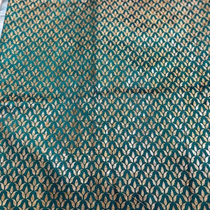 May include: Teal fabric with a repeating pattern of gold leaf stylized floral motifs.