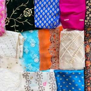 May include: Assortment of fabric swatches in various colors and patterns, including floral, geometric, and embroidered designs. The fabrics are arranged in a grid pattern.