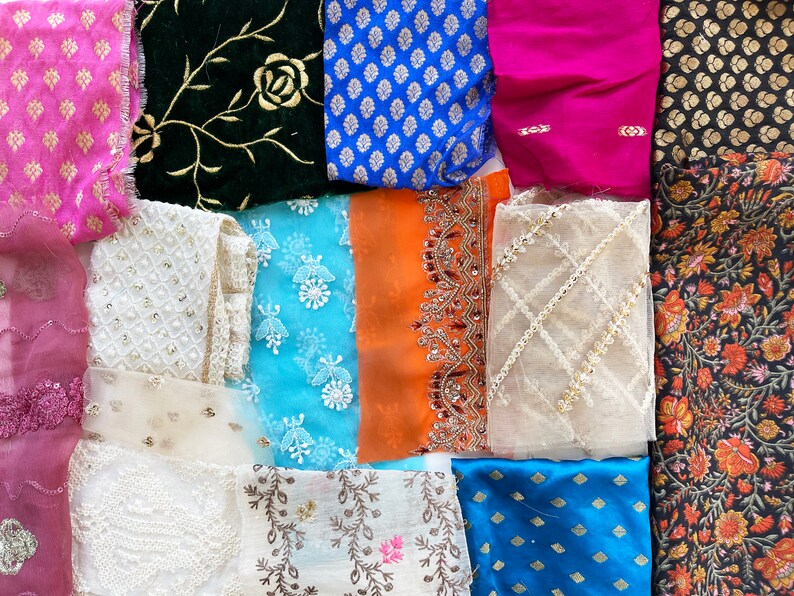 May include: Assortment of fabric swatches in various colors and patterns, including floral, geometric, and embroidered designs. The fabrics are arranged in a grid pattern.