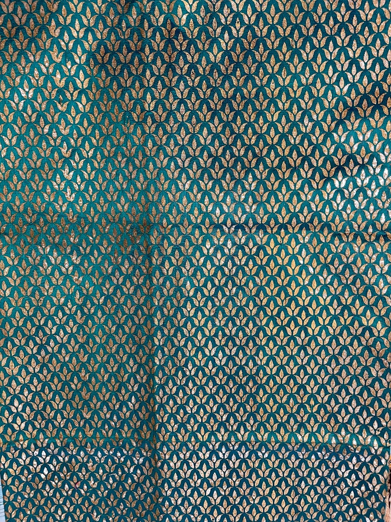 May include: Teal fabric with a gold leaf pattern. The fabric has a subtle sheen and a soft texture.