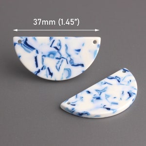 May include: Two white and blue marbled half-circle acrylic pendant charms with a hole at the top. The charms measure 1.45 inches in diameter. 37mm (1.45")