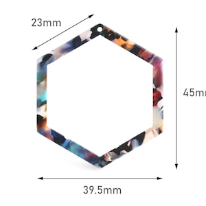 May include: A colorful hexagonal frame made of acrylic with a mottled pattern. The frame measures 4.5 inches by 3.9 inches and has a hole at the top for hanging.