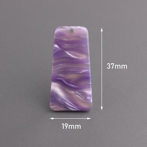 May include: Purple and white marbled plastic pendant with a hole at the top. The pendant is 37 mm tall and 19 mm wide.