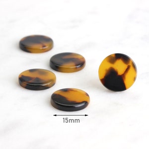 Puede incluir: Cinco botones redondos de carey marrón y negro, cada uno con un diámetro de 15 mm.