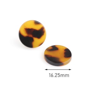 May include: Two round, brown and yellow patterned resin buttons, each measuring 1.625 inches in diameter.