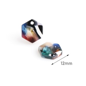 May include: Two colorful hexagonal resin charms with a hole for hanging. The charms are approximately 12 mm in size and feature a swirling pattern of black, white, blue, green, and red.