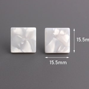 Puede incluir: Dos cuentas cuadradas blancas con efecto marmolado, cada una de 1,55 cm. Las cuentas tienen un acabado nacarado y están sobre un fondo gris. Ideales para la fabricación de joyas o proyectos de artesanía.