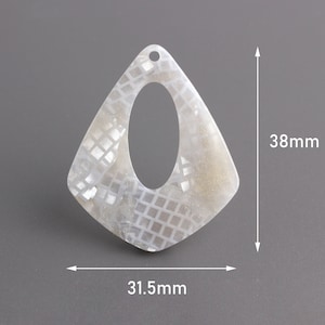 May include: White, pearlescent, geometric pendant with a large oval opening. The pendant measures 38 mm in height and 31.5 mm in width.