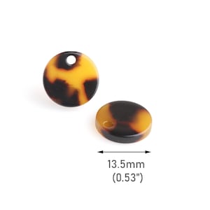 Peut inclure: Deux breloques rondes en plastique brun et jaune avec un trou au centre. Les breloques mesurent 13,5 mm (0,53 pouce) de diamètre.