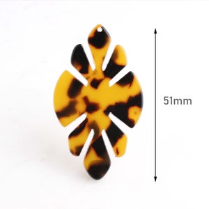 May include: A brown and black tortoiseshell patterned resin leaf with a hole at the top. The leaf is 51 mm tall.