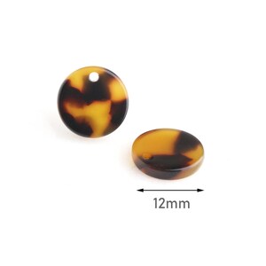 May include: Two brown and yellow patterned round resin beads with a hole for stringing. The beads are 12 mm in diameter.