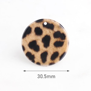 May include: A round, brown and black leopard print resin embellishment with a hole in the center. The embellishment measures 30.5 mm in diameter.