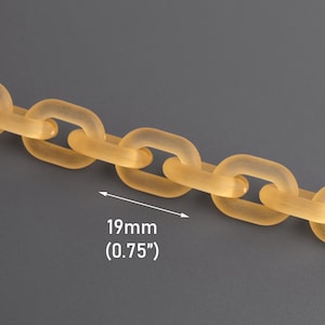 Puede incluir: Primer plano de una cadena hecha de eslabones translúcidos de color naranja claro. Cada eslabón es rectangular con esquinas redondeadas. La cadena mide 19 mm de ancho. El fondo es gris liso.