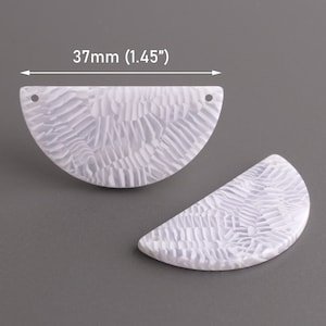 May include: Two white, semi-circular, plastic pieces with a textured surface and a hole at the top. The pieces measure 1.45 inches in diameter. 37mm (1.45")