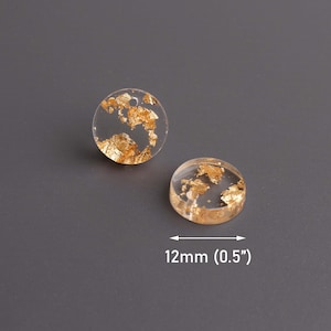 May include: Two clear round resin charms with gold leaf flakes inside. The charms are 0.5 inches in diameter.