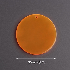 May include: Orange acrylic circle with a hole in the centre, measuring 35mm in diameter.