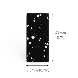 May include: A rectangular black object with white splatters, measuring 1.7 inches in height and 0.75 inches in width. The object has rounded corners and a speckled pattern. The dimensions are clearly labeled.