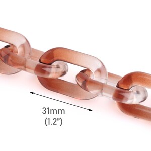 May include: Close-up of a transparent brown chain with rectangular links. The chain links are 31mm (1.2 inches) long. The chain is made of a clear, glossy material.