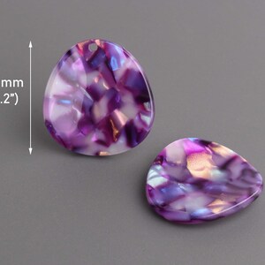 May include: Two purple and white iridescent resin cabochons, each measuring 1.2 inches in diameter. The cabochons have a marbled pattern and a glossy finish.