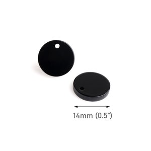 May include: Two black round metal tags with a hole in the center. The tags are 0.5 inches in diameter.