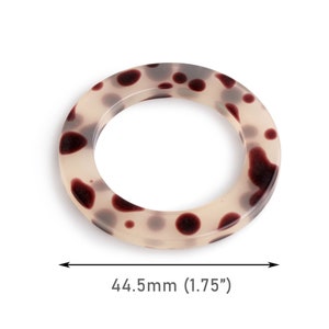 May include: A white ring with brown spots, measuring 1.75 inches in diameter.
