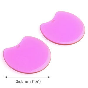 May include: Two pink, rounded, plastic shapes with a hole in the top. The shapes are approximately 1.4 inches wide.