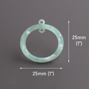 May include: A light green, round, plastic ring with a hole at the top. The ring is 1 inch in diameter.