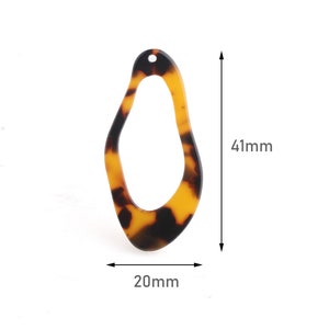 May include: An abstract-shaped pendant with a tortoiseshell pattern. The pendant is 41mm long and 20mm wide, featuring a hole at the top for stringing. The color scheme includes shades of brown and amber.